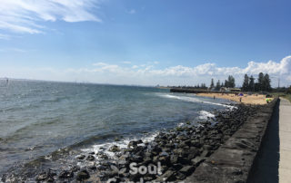 view of the sky, the clouds and rocky shore at Melbourne beach