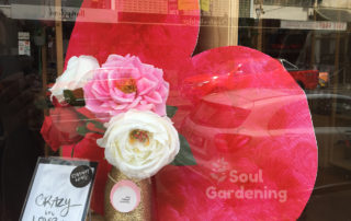 heart and flowers with crazy love card through shop window with reflections