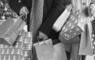 the psychological relationship with money and shopping - shows people shopping with bags